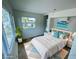 Bright bedroom with a large window, wood floors and furnished with beach-themed decor at 8219 Drew St, Englewood, FL 34224