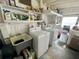 White laundry room with stacked shelves filled with cleaning supplies, laundry sink, washer and dryer at 8219 Drew St, Englewood, FL 34224