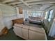 Sitting area featuring exposed rafters, concrete flooring, gray sofa, and vintage buffet at 8219 Drew St, Englewood, FL 34224