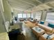 Bright, staged living room with wicker furniture, white cushions, and view of washer and sink at 8219 Drew St, Englewood, FL 34224