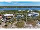 Aerial view of a vacant lot outlined in white, showcasing waterfront property and lush foliage at 8270 Manasota Key Rd, Englewood, FL 34223