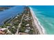 Stunning aerial view of beachfront property with lush greenery and turquoise waters at 8270 Manasota Key Rd, Englewood, FL 34223