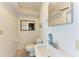 Simple bathroom featuring a toilet, sink, small vanity, mirror and storage shelf at 8270 Manasota Key Rd, Englewood, FL 34223