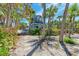 Charming beach house with lush landscaping, a walkway to the beach, and beautiful palm trees at 8270 Manasota Key Rd, Englewood, FL 34223