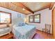 Cozy bedroom with wood ceilings, tile floors, and two windows at 8270 Manasota Key Rd, Englewood, FL 34223