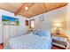 Charming bedroom features wooden ceilings, tile floors, and side tables with lamps at 8270 Manasota Key Rd, Englewood, FL 34223
