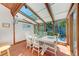 Sunroom dining area features a skylight, wood beams, and views of the yard at 8270 Manasota Key Rd, Englewood, FL 34223