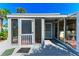 Charming exterior of this beach home with a screened porch and a glimpse of the interior dining area at 8270 Manasota Key Rd, Englewood, FL 34223