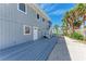 Charming beach house exterior with a deck, white trim, and pathway to the sandy shores at 8270 Manasota Key Rd, Englewood, FL 34223