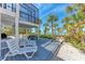 Inviting outdoor deck with beach access, featuring lounge seating, picnic table, and an upper-level screened balcony at 8270 Manasota Key Rd, Englewood, FL 34223