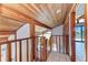 Hallway with wood railing and ceiling and tile floors, leading to an ocean view at 8270 Manasota Key Rd, Englewood, FL 34223