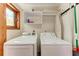 Functional laundry room featuring a washer, dryer, storage, and natural light at 8270 Manasota Key Rd, Englewood, FL 34223