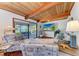 Comfortable living room with wood beamed ceiling, water view, and nautical-themed furniture at 8270 Manasota Key Rd, Englewood, FL 34223