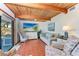 Cozy living room with wood beamed ceiling, tile flooring, and a view of the outdoors at 8270 Manasota Key Rd, Englewood, FL 34223