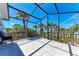 Spacious screened patio offering breathtaking ocean views through the palms at 8270 Manasota Key Rd, Englewood, FL 34223