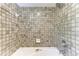Shower stall featuring neutral-toned square tile walls and silver shower head at 8270 Manasota Key Rd, Englewood, FL 34223