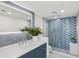 Modern bathroom with blue accent wall, glass shower, and a large mirror at 888 Blvd Of The Arts # 1402, Sarasota, FL 34236