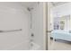 White bathroom with a white tiled tub/shower combo and a view to the bedroom at 902 Gibbs Rd # 282, Venice, FL 34285