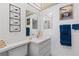 Bright bathroom with a large mirror and an array of personal items, flowers, and decor at 902 Gibbs Rd # 282, Venice, FL 34285