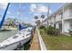 View of boat dock and condo, with a sailboat docked nearby, offering waterfront living at 902 Gibbs Rd # 282, Venice, FL 34285