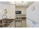 Efficient kitchen with stainless steel sink, white appliances, and ample cabinet space at 902 Gibbs Rd # 282, Venice, FL 34285