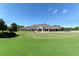 An exterior view of the clubhouse with golf course in the foreground on a sunny day at 9570 High Gate Dr # 1722, Sarasota, FL 34238