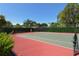 Outdoor tennis court with green surface surrounded by green foliage at 9570 High Gate Dr # 1722, Sarasota, FL 34238