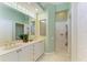 Bright bathroom featuring double vanity, glass block window, and walk-in shower at 9734 51St Terr E, Bradenton, FL 34211