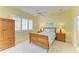 Cozy bedroom with a wooden sleigh bed, plantation shutters, and ensuite bathroom at 9734 51St Terr E, Bradenton, FL 34211