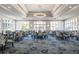Elegant dining room with a stunning chandelier, large windows, and patterned carpet, offering a refined ambiance at 9734 51St Terr E, Bradenton, FL 34211