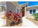 The front entrance is beautifully adorned with bright greenery, leading to a charming red door at 9734 51St Terr E, Bradenton, FL 34211