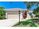 Well-manicured front yard with mature trees, a lamp post, and lush green grass creating a welcoming entrance at 9734 51St Terr E, Bradenton, FL 34211