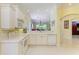 Bright kitchen overlooking the living area, featuring white cabinetry and modern appliances at 9734 51St Terr E, Bradenton, FL 34211