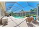 Enclosed pool area with blue screen, multiple seating areas and a small waterfall feature at 9734 51St Terr E, Bradenton, FL 34211