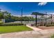 Exterior view of tennis courts with seating, lighting, and lush landscaping at 9734 51St Terr E, Bradenton, FL 34211