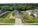 Aerial view of a well-maintained home featuring lush landscaping, a paved driveway, and a serene neighborhood setting at 9767 50Th Street E Cir, Parrish, FL 34219