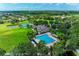 Aerial view highlighting the community pool, clubhouse, tennis courts, and lush landscaping at 9767 50Th Street E Cir, Parrish, FL 34219