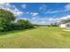Expansive backyard featuring a lush lawn with direct access to a scenic pond and peaceful green surroundings at 9767 50Th Street E Cir, Parrish, FL 34219