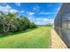 Spacious backyard with well-maintained lawn, green foliage, and views of a tranquil waterfront area at 9767 50Th Street E Cir, Parrish, FL 34219