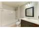 Bright bathroom features a shower and bathtub combo and a dark wood vanity at 9767 50Th Street E Cir, Parrish, FL 34219