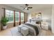 Cozy bedroom with large windows, neutral tones, ceiling fan, and stylish decor for a relaxing ambiance at 9767 50Th Street E Cir, Parrish, FL 34219