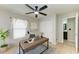 Neutral bedroom featuring a closet, a ceiling fan, a large window, and an ensuite bathroom at 9767 50Th Street E Cir, Parrish, FL 34219