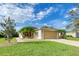Charming single-story home with a manicured lawn, mature landscaping, and a two-car garage with a warm beige color scheme at 9767 50Th Street E Cir, Parrish, FL 34219