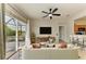Living room showing ceiling fan, tile floors, sofa and a view of the outdoor patio through the sliding glass doors at 9767 50Th Street E Cir, Parrish, FL 34219