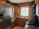 Kitchen features stainless steel appliances, granite counters, and wood cabinets with greenery on top at 1036 Hope St, Venice, FL 34285