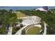 Outdoor amphitheater setting with elegant white trellis, landscaped grounds and distant glimpses of Sarasota Bay at 1110 Villagio Cir # 103, Sarasota, FL 34237