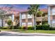 Inviting two-story condo featuring manicured landscaping, neutral color palette, and a terracotta tile roof at 1110 Villagio Cir # 103, Sarasota, FL 34237