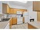 Bright kitchen featuring tile floors, white appliances, wood cabinets, and ample counter space at 1110 Villagio Cir # 103, Sarasota, FL 34237