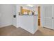 Open-concept kitchen featuring tile flooring, wood cabinetry, white appliances, and breakfast bar at 1110 Villagio Cir # 103, Sarasota, FL 34237