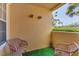 Cozy patio featuring artificial grass, two wicker chairs, and a small table for outdoor relaxation at 1110 Villagio Cir # 103, Sarasota, FL 34237